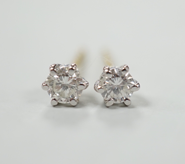 A pair of 750 and solitaire diamond set ear studs, gross weight 0.9 grams.